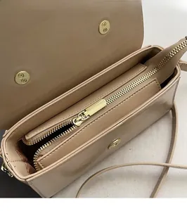 Détail de la fermeture éclair métallique et des compartiments internes du sac beige