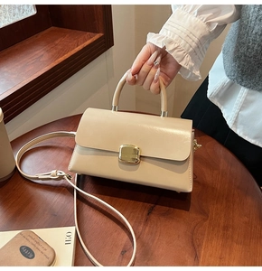 Détail d'un sac à main beige en similicuir avec boucle dorée et bandoulière réglable