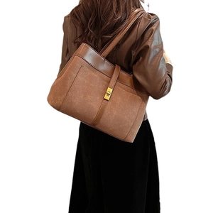 Brown leather and suede patchwork tote bag with gold lock buckle and minimalist commuter style