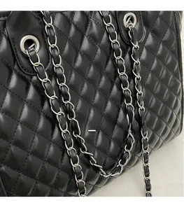 Nahaufnahme der schwarzen Stepptasche mit Rautenmuster und silbernem Kettenriemen