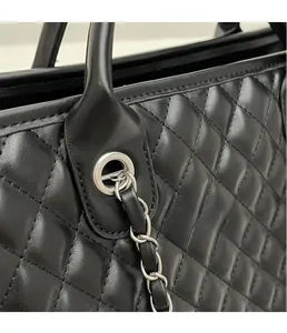 Detail der schwarzen gesteppten Ledertasche mit silberner Öse und Kettenriemen