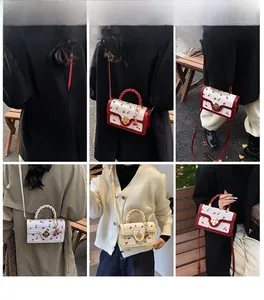 Close-up of cherry print handbags with twisted handles and floral metal clasps