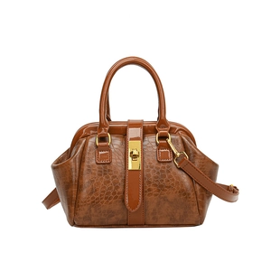 Dunkelbraune Handtasche mit glänzender Krokostruktur und elegantem Metalldrehverschluss