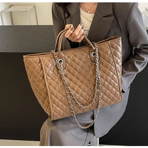 Detailansicht der braunen Stepp-Tragetasche mit Metallkette und Leder-Tragegriff