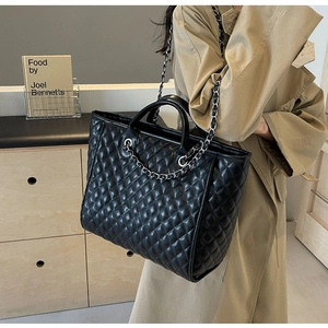 Detailansicht der schwarzen gesteppten Shopper-Tasche mit silbernen Kettenriemen