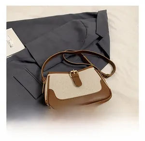 Close-up of retro color-block handbag with ivory canvas and brown leather details