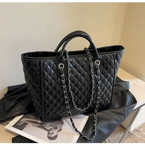 Details der schwarzen gesteppten Shopper-Tasche mit Kettenriemen und Doppelgriff