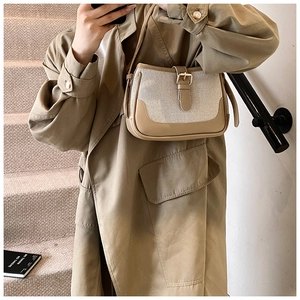 Detail shot of vintage canvas and leather crossbody bag with metallic buckle closure