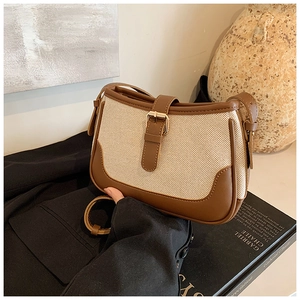 Detail of vintage canvas and brown leather crossbody bag with metallic buckle accent