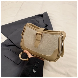 Detail of khaki canvas and leather crossbody bag with metal buckle and adjustable strap