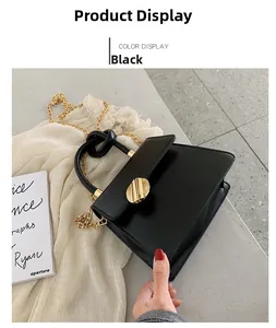 Detail of black PU leather handbag with gold circular buckle and elegant chain strap