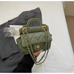 Detail of dark green quilted handbag with golden curved handle and metal chain strap