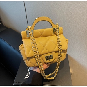 Close-up of a yellow quilted handbag featuring a metal handle and elegant chain strap