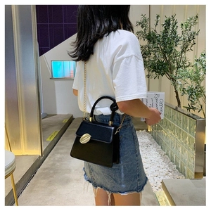 Close-up of black PU handbag featuring a knotted handle and gold metal buckle detail