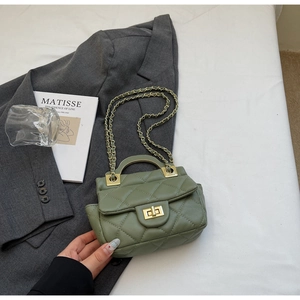 Sage green quilted handbag with gold metal handle and chain strap on a stylish background