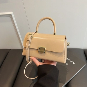 Sac à main minimaliste en cuir beige avec boucle dorée et poignée en décor lifestyle