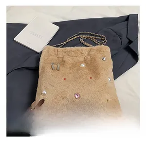 Détail du sac seau en peluche camel avec perles et pendentif coeur rose décoratif