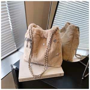 Détail du sac seau en fausse fourrure pelucheuse avec perles et nœud en strass