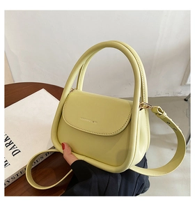 Detail of a lemon yellow mini leather handbag featuring Fashion & Bags logo on a wood table