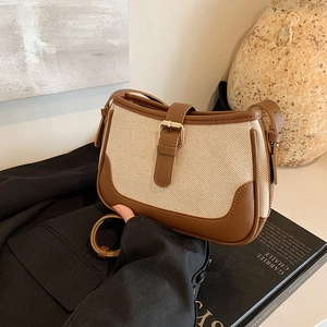 Vintage crossbody bag in brown leather and canvas with adjustable strap shown on a table