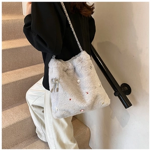 Détail du sac fourre-tout gris clair en peluche avec perles et breloque nœud argenté