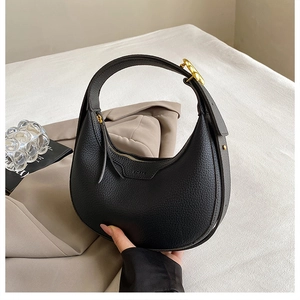 Detail of black lychee grain hobo bag featuring gold hardware and logo on leather
