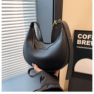 Detail of black lychee grain leather hobo bag with KORSN logo and gold zipper