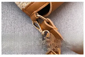 Détail du tissage en paille avec coutures en cuir marron et crochets métalliques dorés