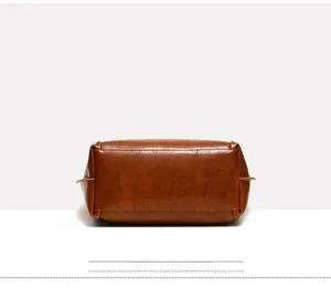 Dettaglio della base della borsa in pelle marrone caramello con texture e cuciture fini