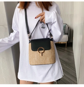 Détail du sac seau en paille avec rabat en cuir noir et boucle anneau doré élégant