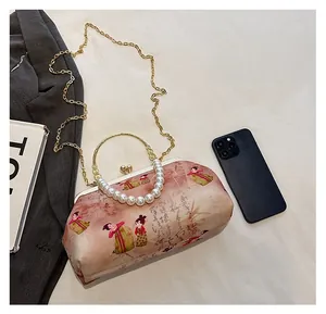Detailed size comparison of embroidered vintage bag with phone and essentials
