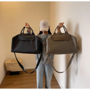 Detail of black and taupe large travel tote bags with detachable straps for short trips