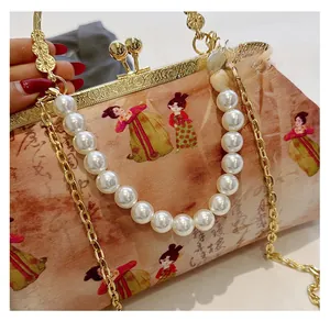Detail of vintage style crossbody bag with pearl handle and traditional embroidery