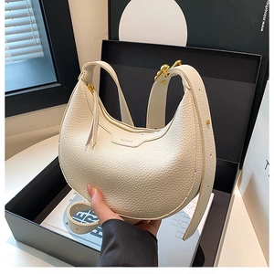 Detailed macro of cream lychee texture leather handbag with gold zipper and embossed logo