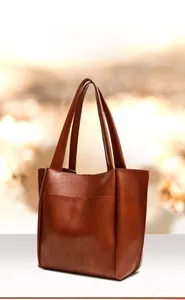 Dettaglio della borsa tote in pelle arancione con trama di qualità e manico sottile
