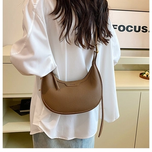Brown lychee leather crescent hobo bag shown with adjustable strap and brand logo