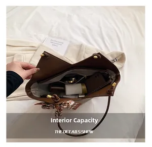 Inside view of brown tote bag showing large capacity with phone, perfume, and lotion