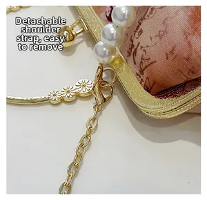 Detail of pearl handle and floral embossed gold frame on vintage embroidered handbag