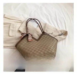 Detail of checkered tote bag with brown leather trim and decorative patterned silk scarf