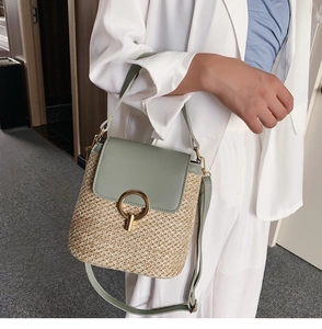 Détail d'un sac seau en paille avec rabat en cuir vert menthe et fermoir en métal doré