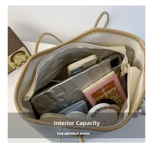 Close-up of large capacity leather tote bag interior showing various daily essentials
