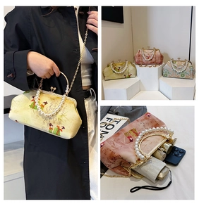 Detail showing vintage embroidered evening bag interior space and elegant pearl handle