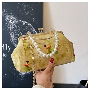 Detail of vintage evening bag with pearl handle and traditional lady portrait print
