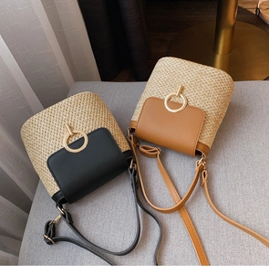 Détail de sacs seaux en paille avec grandes boucles dorées et rabats en cuir chic