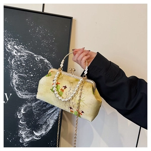 Detail of vintage beige brocade bag with Chinese painting, pearl handle and gold chain