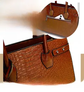 Detail of embossed brown leather handbag with back zipper pocket and precision stitching