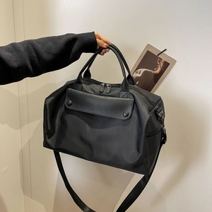 Large black travel handbag with crossbody strap and front pocket in nylon material