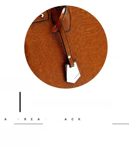 Close-up of brown embossed crocodile leather handbag with fine stitching and metal hardware