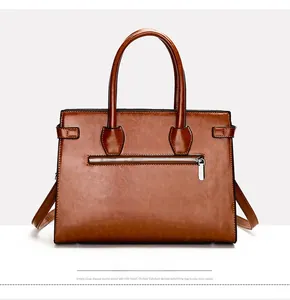 Close-up of minimalist brown tote bag with back zipper pocket and polished texture