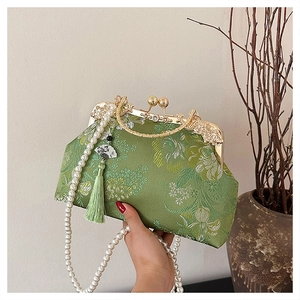 Détail du sac coquille vert vintage avec broderie florale et bandoulière perle